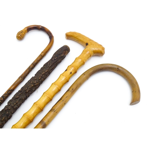 1411 - Sticks / Canes : Four assorted walking stick / canes to include an example with carved Oriental deco... 