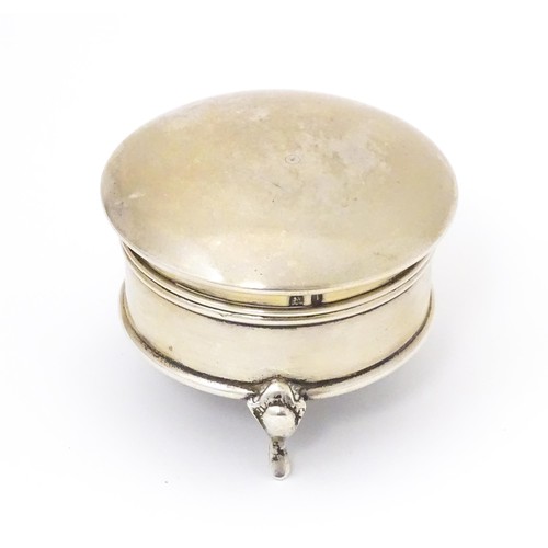 569 - A silver ring box of circular form with hinged lid and raised on three feet. Hallmarked Birmingham 1... 