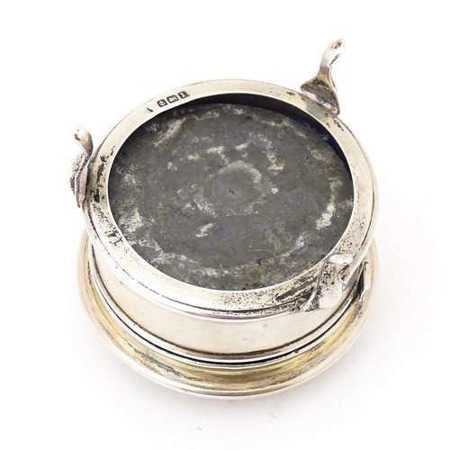 569 - A silver ring box of circular form with hinged lid and raised on three feet. Hallmarked Birmingham 1... 