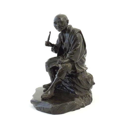 1148 - A Japanese cast sculpture modelled as a seated man on a rock smoking a kiseru pipe. Approx. 9 1/2