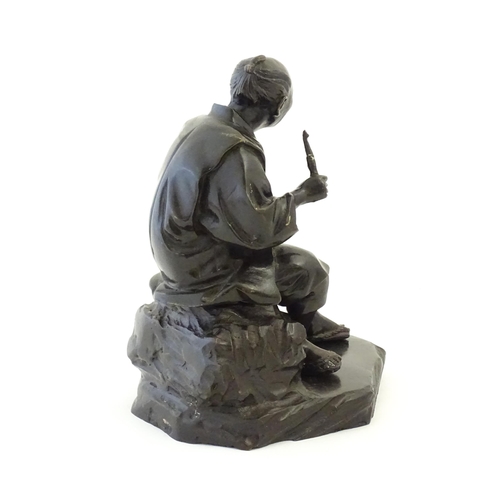 1148 - A Japanese cast sculpture modelled as a seated man on a rock smoking a kiseru pipe. Approx. 9 1/2