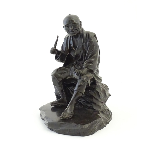 1148 - A Japanese cast sculpture modelled as a seated man on a rock smoking a kiseru pipe. Approx. 9 1/2