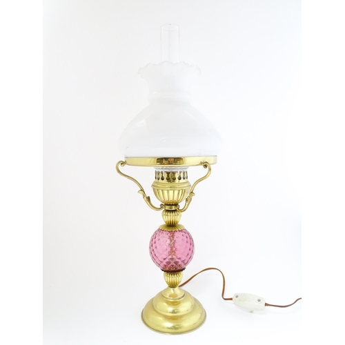 1572 - A mid 20thC table lamp formed as an oil lamp with cranberry glass detail. Approx 19 1/2