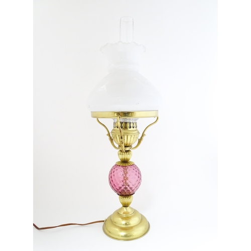 1572 - A mid 20thC table lamp formed as an oil lamp with cranberry glass detail. Approx 19 1/2