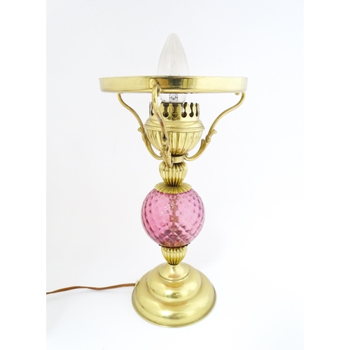 1572 - A mid 20thC table lamp formed as an oil lamp with cranberry glass detail. Approx 19 1/2