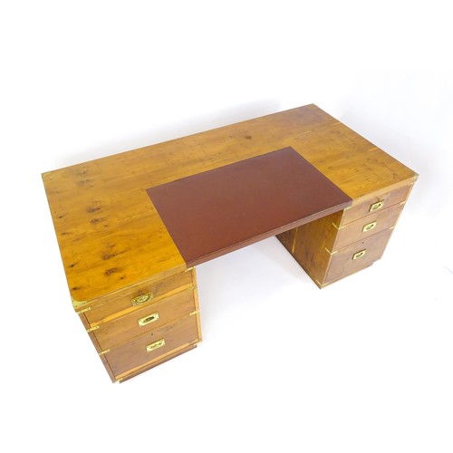 1667 - A campaign style yew wood veneered partners desk, with brass mounts to the corners of the desk top a... 