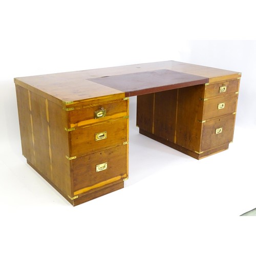 1667 - A campaign style yew wood veneered partners desk, with brass mounts to the corners of the desk top a... 