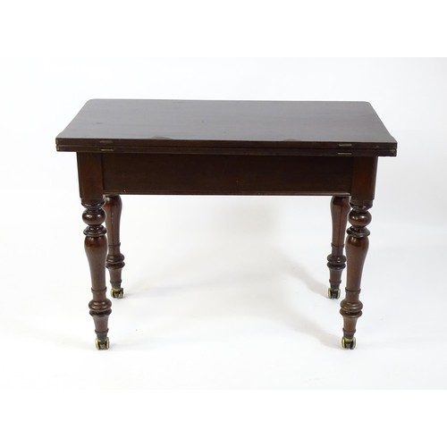 1623 - A 19thC mahogany tea table, with a hinged top above four turned tapering legs terminating in unusual... 