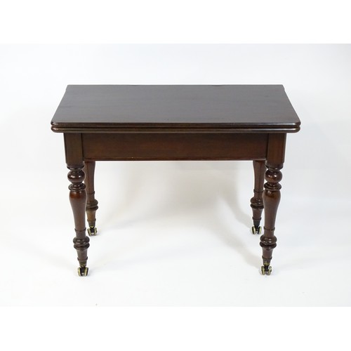 1623 - A 19thC mahogany tea table, with a hinged top above four turned tapering legs terminating in unusual... 