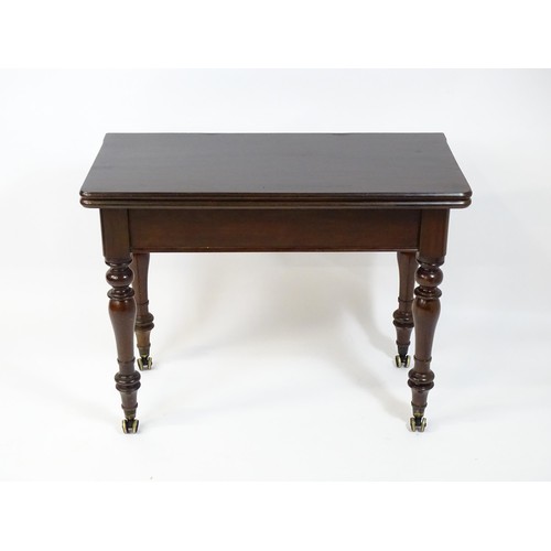 1623 - A 19thC mahogany tea table, with a hinged top above four turned tapering legs terminating in unusual... 