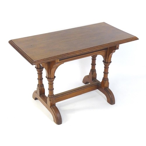 1602 - A late 19thC pine Gothic centre table, with a rectangular moulded top above four column formed taper... 