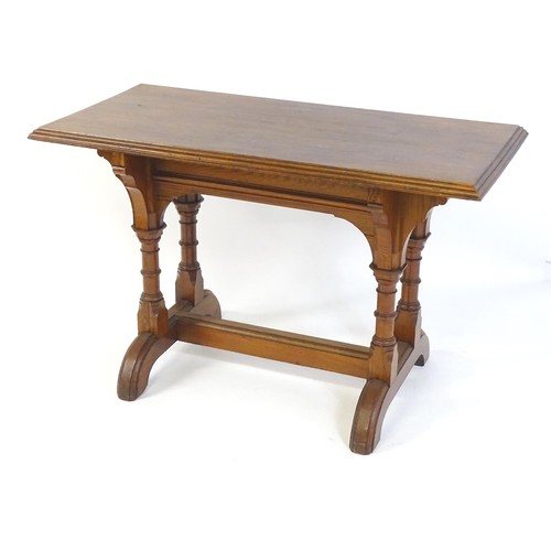 1602 - A late 19thC pine Gothic centre table, with a rectangular moulded top above four column formed taper... 