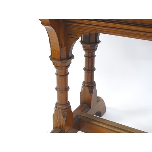 1602 - A late 19thC pine Gothic centre table, with a rectangular moulded top above four column formed taper... 