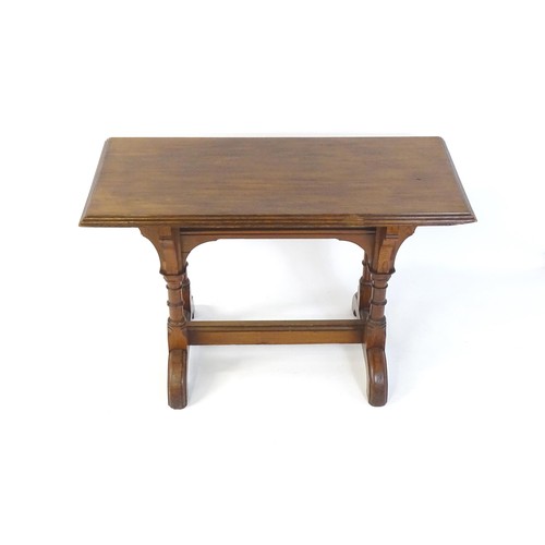 1602 - A late 19thC pine Gothic centre table, with a rectangular moulded top above four column formed taper... 