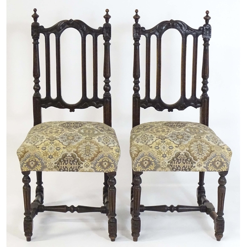 80 - A pair of late 19thC carved oak side chairs surmounted by turned finials and having carved cresting ... 