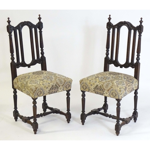 80 - A pair of late 19thC carved oak side chairs surmounted by turned finials and having carved cresting ... 