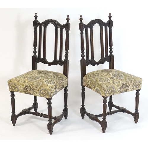 80 - A pair of late 19thC carved oak side chairs surmounted by turned finials and having carved cresting ... 