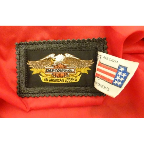 85 - A ladies Harley Davidson black leather biker jacket, with red lining and eagle logo to back. Size me... 