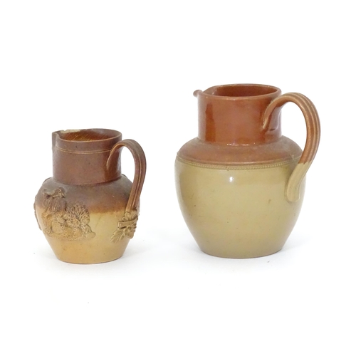 121 - A Doulton Lambeth two tone jug with relief decoration. Together with a two tone stoneware jug with C... 