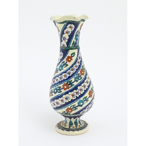 128 - An Iznik style vase with banded blue, white and red floral and foliate detail. Approx. 11 1/2