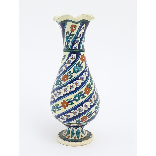 128 - An Iznik style vase with banded blue, white and red floral and foliate detail. Approx. 11 1/2