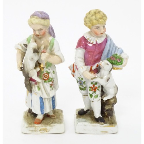 459 - A pair of Continental porcelain figurines, one modelled as a girl with a cat, the other modelled as ... 