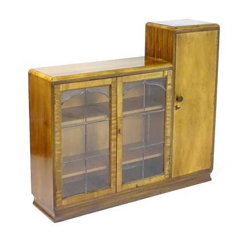 535 - A mid 20thC walnut Art Deco bookcase with two glazed doors and a single walnut door containing shelv... 