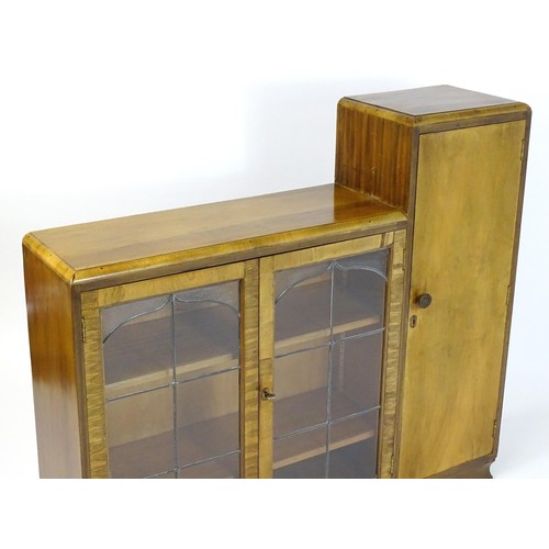 535 - A mid 20thC walnut Art Deco bookcase with two glazed doors and a single walnut door containing shelv... 