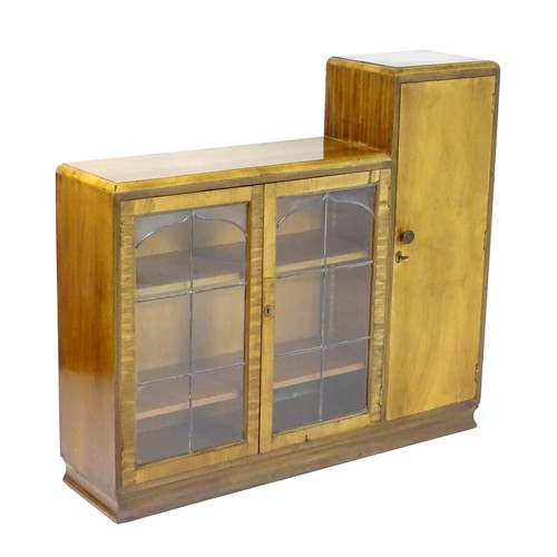 535 - A mid 20thC walnut Art Deco bookcase with two glazed doors and a single walnut door containing shelv... 