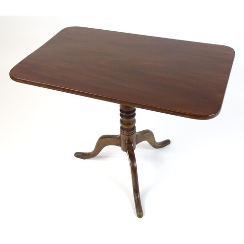 544 - An early 19thC mahogany tripod table with a rectangular top above a turned stem and three cabriole l... 