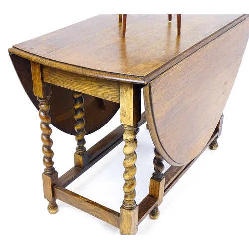 548 - A 20thC oak gateleg table together with a small oval side table raised on tapering legs. The largest... 