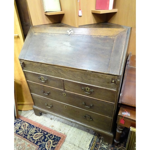 574 - An 18thC oak bureau with fall front over two short over two long drawers with swan neck handles. The... 