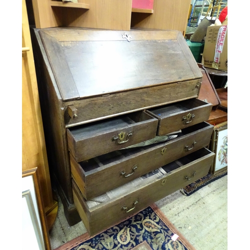 574 - An 18thC oak bureau with fall front over two short over two long drawers with swan neck handles. The... 