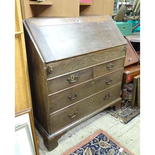 574 - An 18thC oak bureau with fall front over two short over two long drawers with swan neck handles. The... 