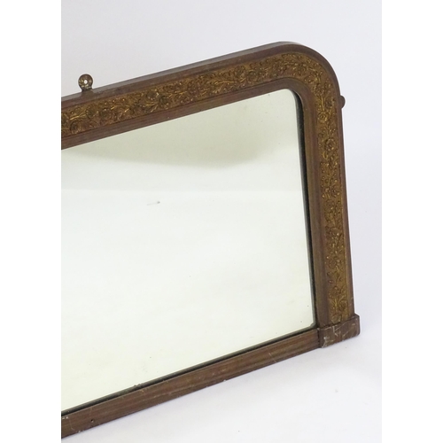 31 - A mid 20thC over mantle mirror with a gilt metal floral rim. 32