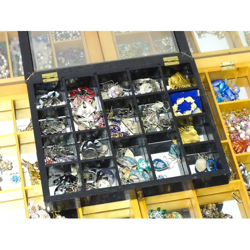 489 - A large quantity of assorted costume jewellery  to include earrings necklaces etc in display cases