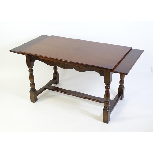 522 - A mid 20thC draw leaf dining table, with four block and turned legs united by a H - stretcher. 48