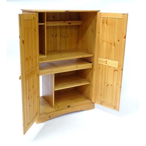 555 - A modern pine cupboard with two panelled doors with turned knob handles and having a fitted interior... 