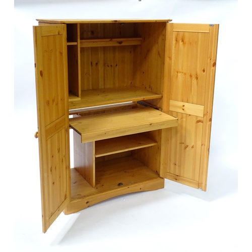 555 - A modern pine cupboard with two panelled doors with turned knob handles and having a fitted interior... 