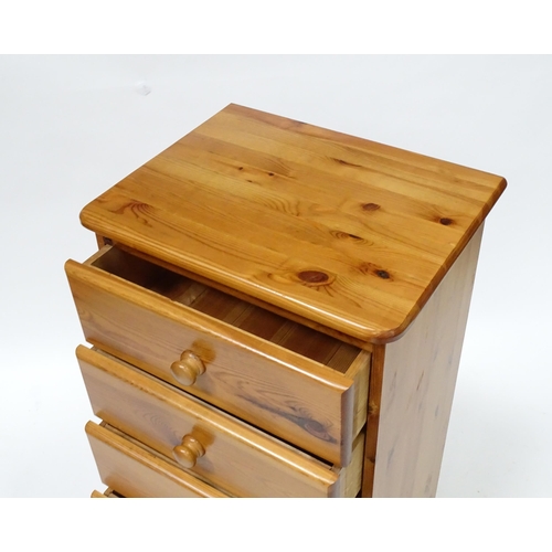 559 - A pine chest of six short drawers with turned wooden handles, raised on four squat bun feet. 2