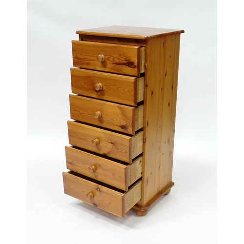 559 - A pine chest of six short drawers with turned wooden handles, raised on four squat bun feet. 2