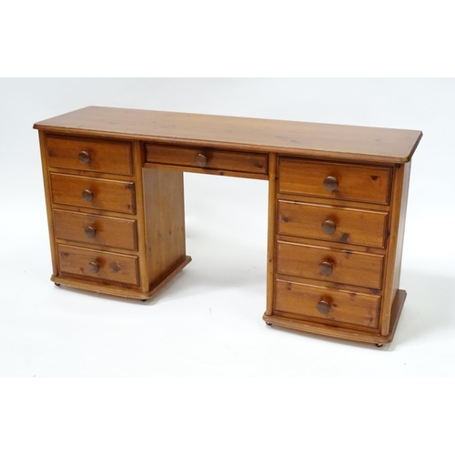 673 - A pine double pedestal desk with two banks of four short drawers and a draw to the centre. Together ... 