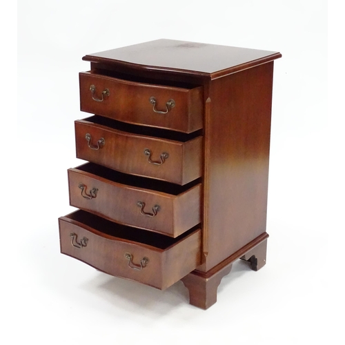 93 - A mahogany veneered chest of drawers with a serpentine front and four short drawers raised on bracke... 