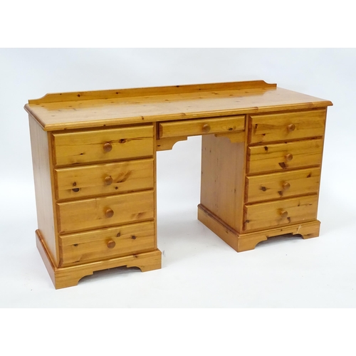 95 - A pine double pedestal desk with a moulded top and a shaped upstand, having two banks of four short ... 