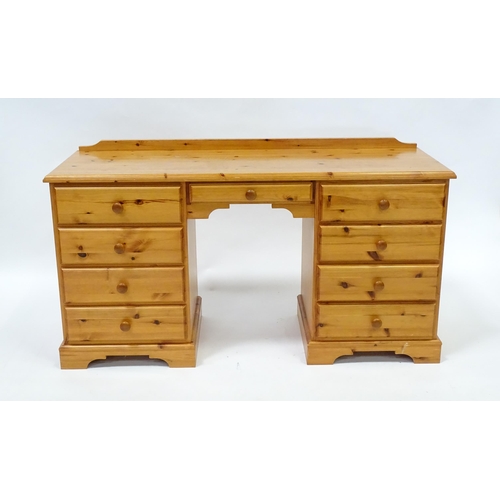 95 - A pine double pedestal desk with a moulded top and a shaped upstand, having two banks of four short ... 