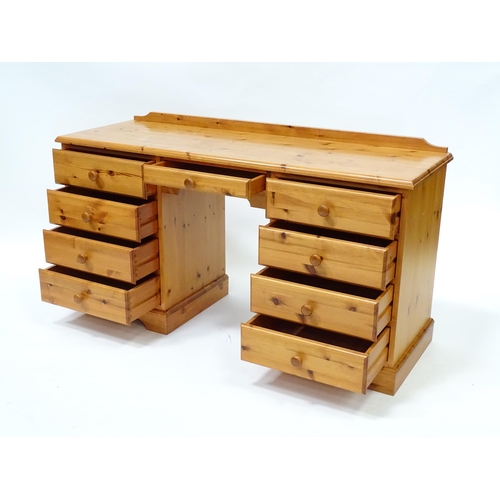 95 - A pine double pedestal desk with a moulded top and a shaped upstand, having two banks of four short ... 