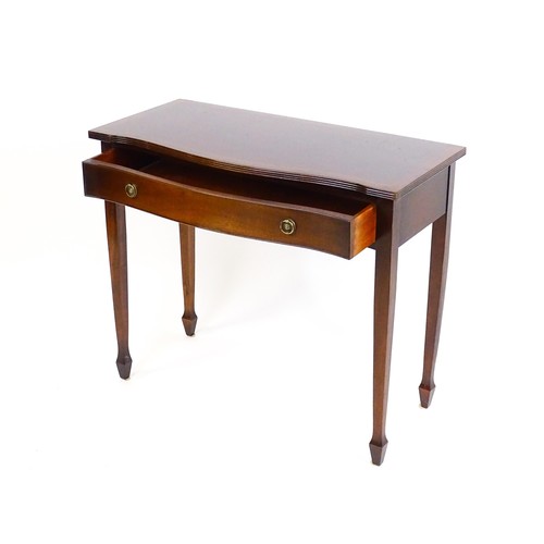 841 - A 20thC mahogany side table, with a serpentine shaped front, reeded edge and decoratively strung top... 