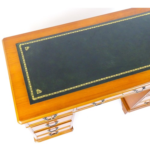 846 - A yew wood veneered double pedestal writing desk with a gold tooled inset leather top, the base comp... 