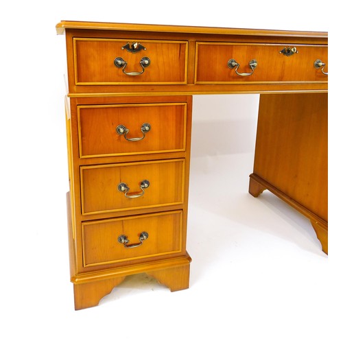 846 - A yew wood veneered double pedestal writing desk with a gold tooled inset leather top, the base comp... 