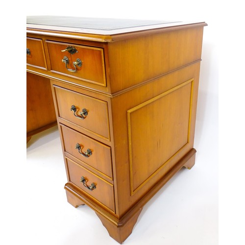 846 - A yew wood veneered double pedestal writing desk with a gold tooled inset leather top, the base comp... 